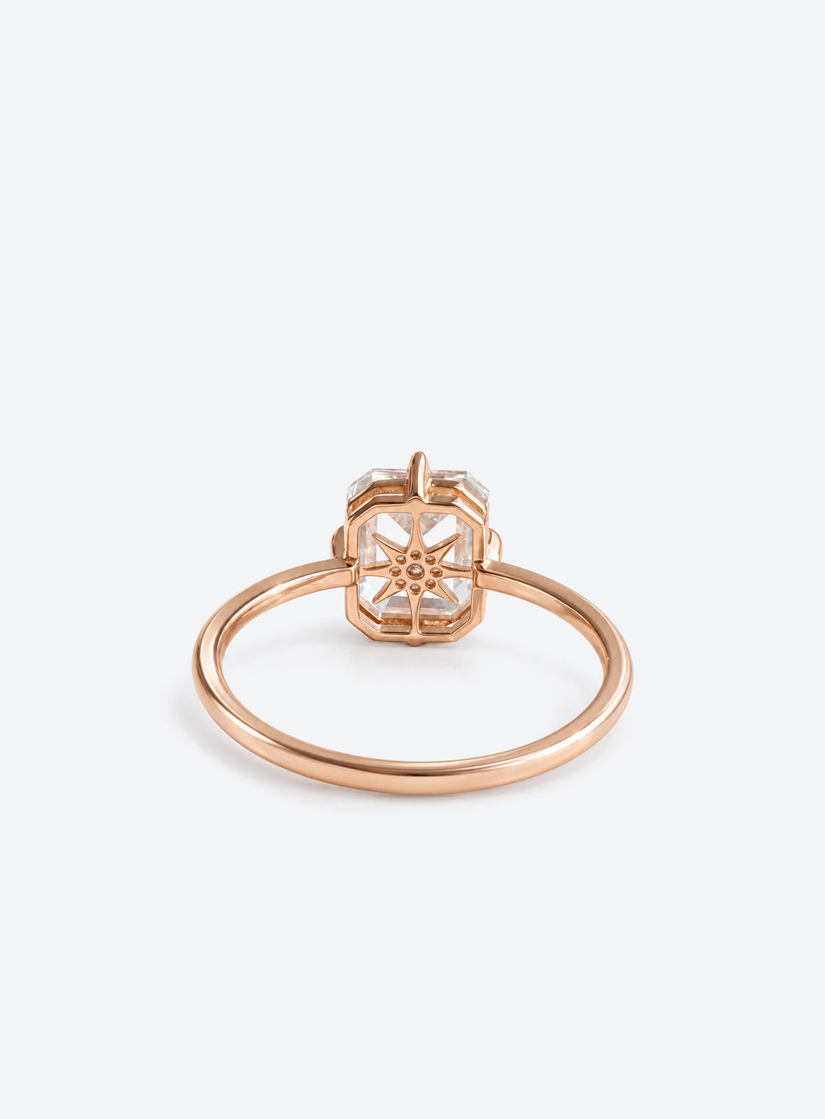 Slim silver or gold ring with clear rectangular centre, starburst motif and small clear accents