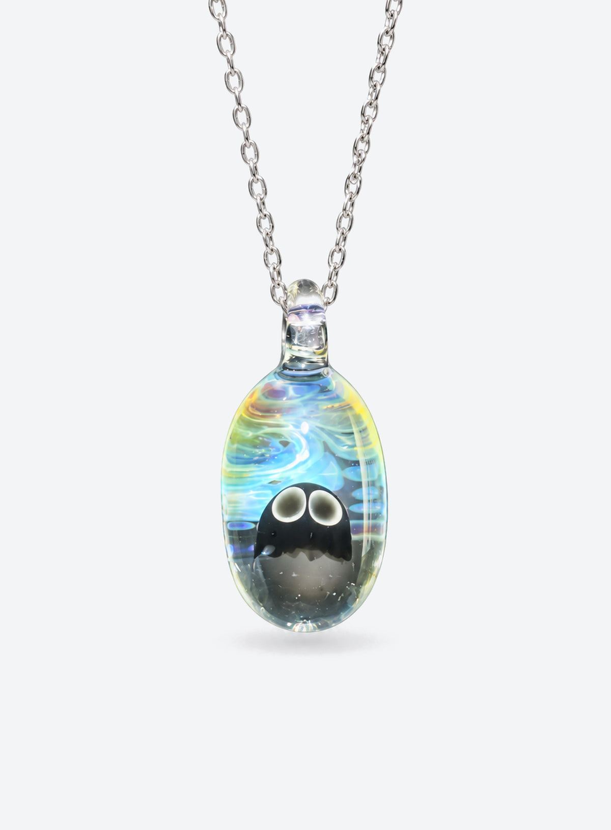 Oval clear glass pendant with a ghost, blue, white, and yellow swirls, and a silver-tone chain
