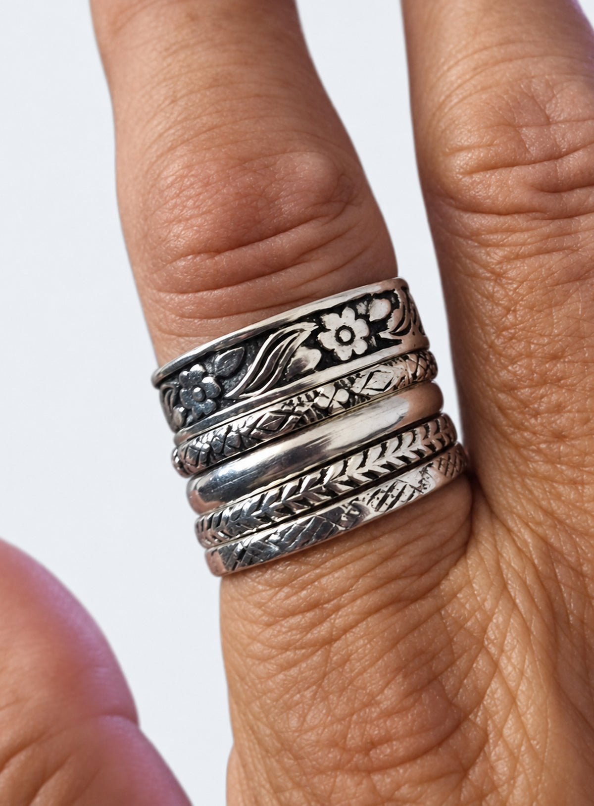 Five sterling silver floral and patterned stacking rings