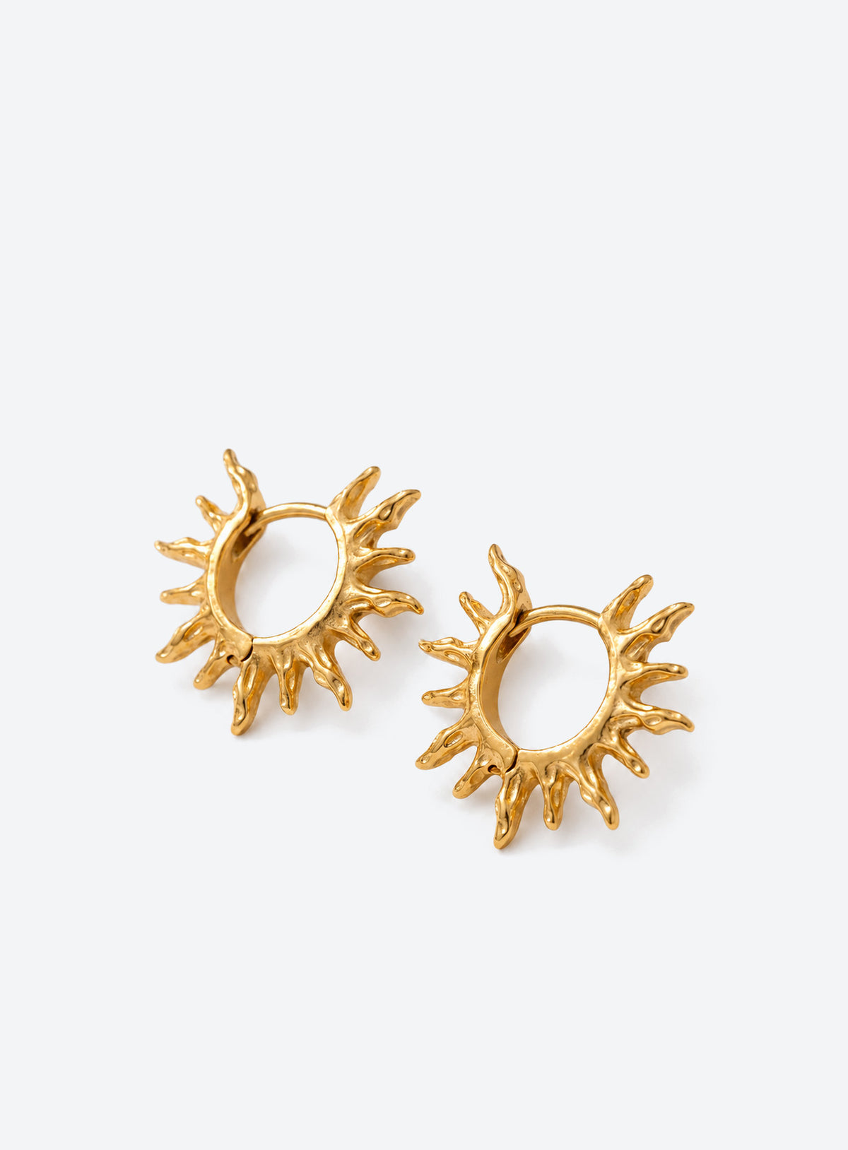 Gold-tone round hoop earrings with pointed sunburst rays around the perimeter