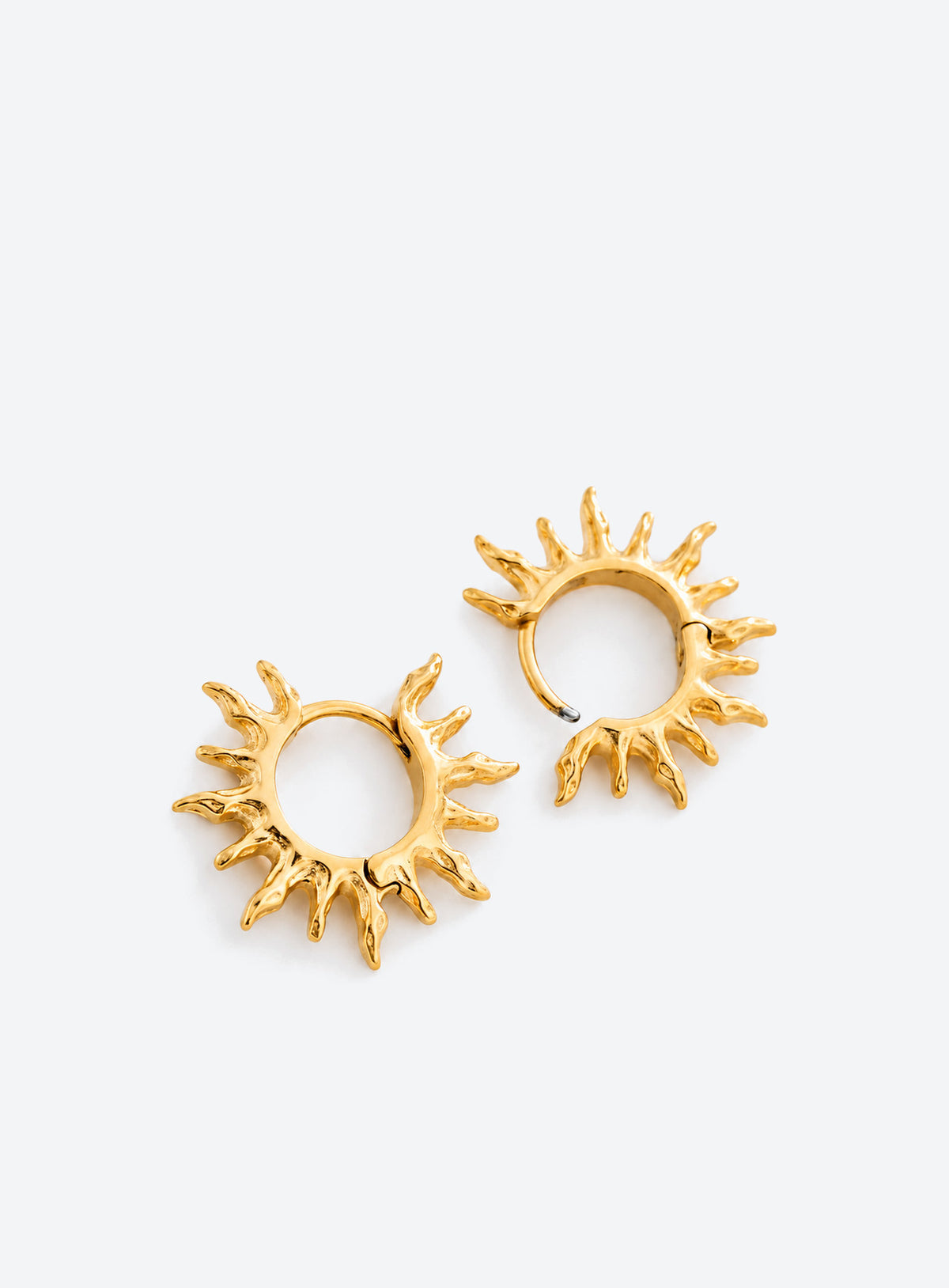 Gold-tone round hoop earrings with pointed sunburst rays around the perimeter