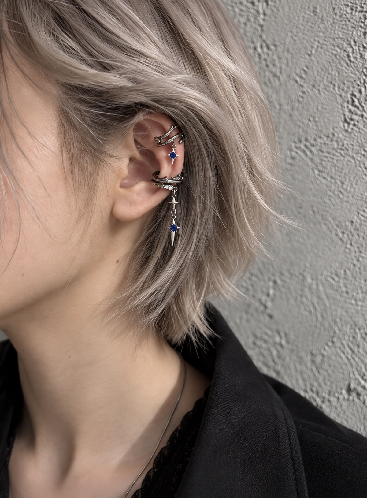 Silver-tone thorn ear cuff with blue accents and a dangling pointed star