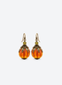 Vintage pumpkin drop earrings with olive-green crystals and amber-orange pumpkin beads on a light studio background