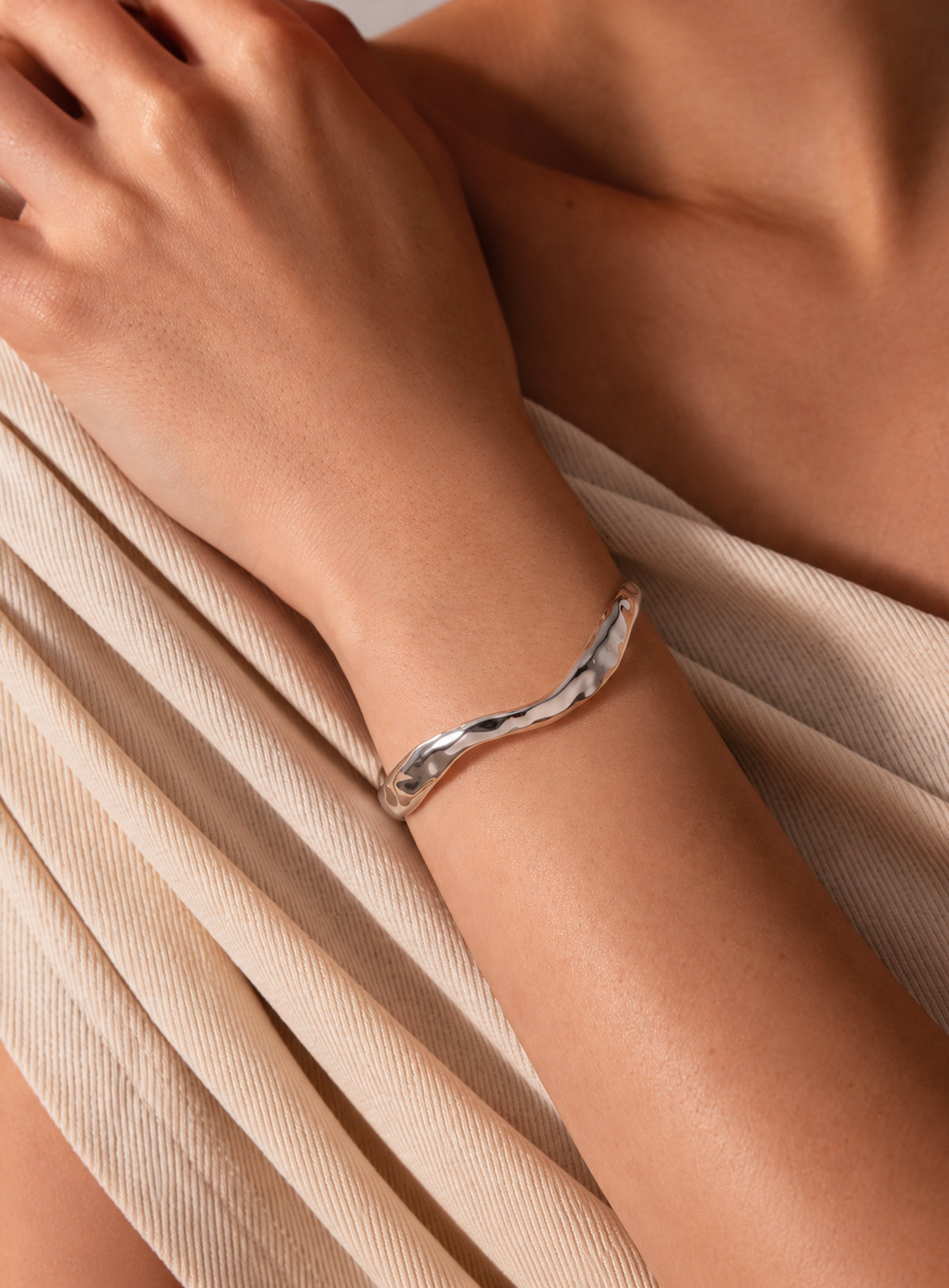 Open cuff bracelet with sculpted wavy edges and a textured polished surface (Silver)