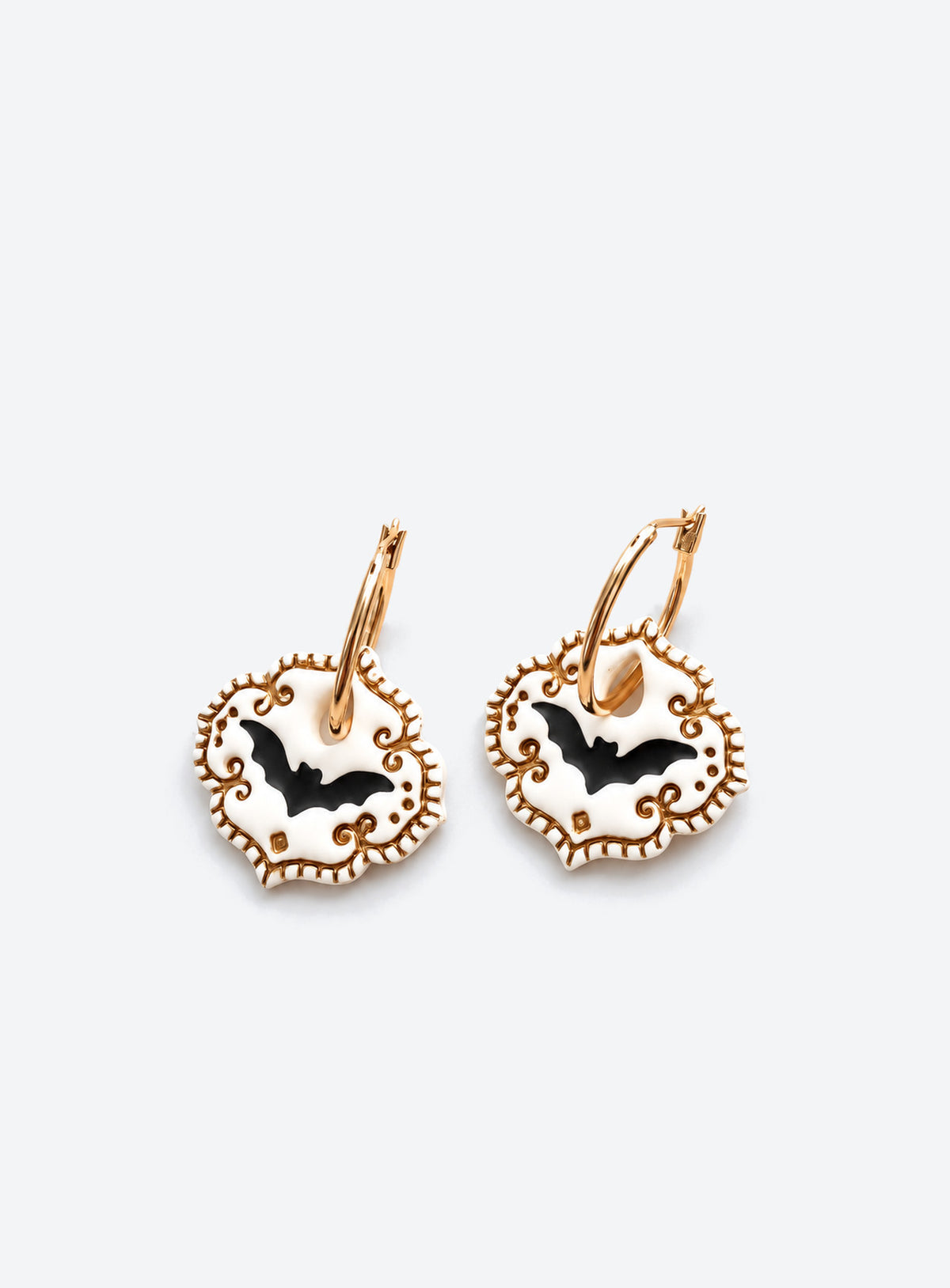 White polymer clay bat earrings with black bat silhouettes, gold scrollwork and gold hoops