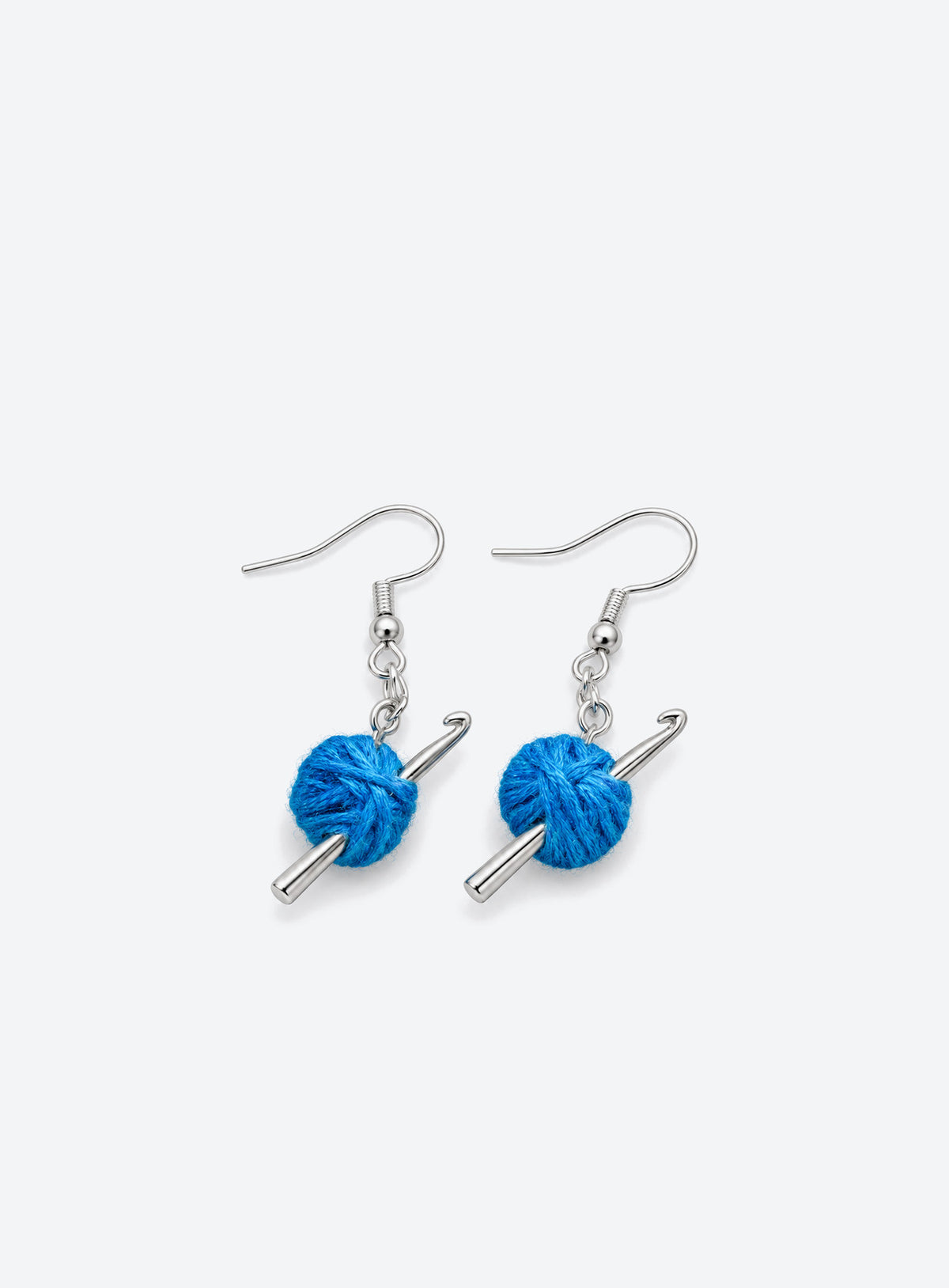 A pair of blue yarn ball earrings with silver-tone crochet hooks and French ear hooks